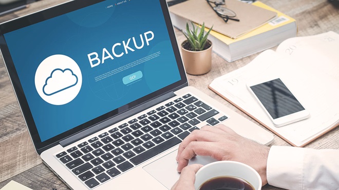 person backing up software on laptop